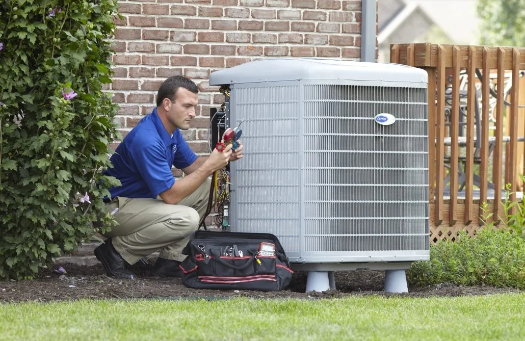 A technician repairing an outdoor HVAC unit