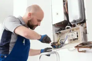 A technician repairing a furnace