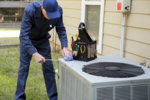 Adult air conditioner Technician services outdoor unit.